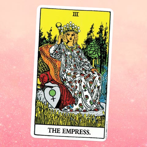 the tarot card the empress, showing a feminine person in a long patterned dress and crown, sitting on a throne in the middle of a field