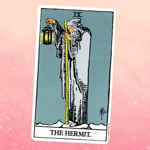 the tarot card the hermit, showing an old man in a beard and a gray robe holding a wooden staff and a lantern