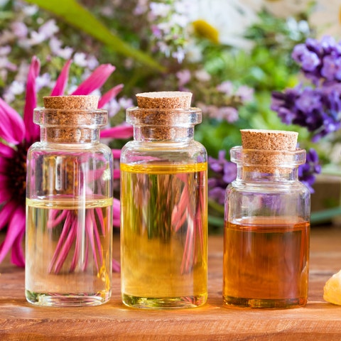 Three bottles of essential oil with frankincense, lavender, echinacea, chamomile and other herbs Three bottles of essential oil with frankincense, lavender, echinacea, chamomile and other herbs